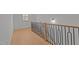 Hallway featuring hardwood floors and black metal railing at 30 Chestnut Oak Dr, Youngsville, NC 27596