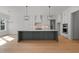 Open-concept kitchen with a large island, modern lighting, and views into a adjacent living space at 30 Chestnut Oak Dr, Youngsville, NC 27596