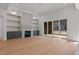 Bright living room featuring a stone fireplace, built-in shelves, and sliding doors to a screened porch at 30 Chestnut Oak Dr, Youngsville, NC 27596