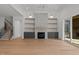 Open-concept living space with a stone fireplace, built-in cabinets and shelves, and access to an outdoor porch at 30 Chestnut Oak Dr, Youngsville, NC 27596