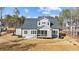 Rear view of gray two-story home, with spacious lawn and screened porch at 30 Chestnut Oak Dr, Youngsville, NC 27596
