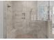Close up of the walk-in shower with rain shower head and bench seating and a picture window at 30 Chestnut Oak Dr, Youngsville, NC 27596