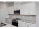 White kitchen cabinets, granite countertops, and stainless steel appliances at 22 Van Winkle St, Lillington, NC 27546