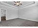 This bedroom features a ceiling fan, tray ceiling, grey walls and carpeted floors at 208 Hillwood Dr, Sanford, NC 27332