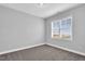 This carpeted bedroom features neutral-toned walls and a window with blinds, creating a bright and airy space at 208 Hillwood Dr, Sanford, NC 27332