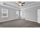 Spacious bedroom with tray ceiling, ceiling fan, two windows and neutral carpeting at 208 Hillwood Dr, Sanford, NC 27332