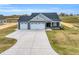 New construction featuring three-car garage, blue siding, grey gables, and a concrete driveway at 208 Hillwood Dr, Sanford, NC 27332