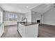 Bright kitchen has stainless steel appliances, white cabinets, and an island with a sink and granite countertop at 208 Hillwood Dr, Sanford, NC 27332
