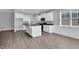 Bright kitchen boasts white cabinetry, stainless appliances and a center island with granite countertops at 208 Hillwood Dr, Sanford, NC 27332
