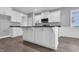 Featuring a granite countertop and sink, this kitchen island has bright white cabinets and hardware at 208 Hillwood Dr, Sanford, NC 27332