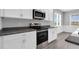 The modern kitchen showcases stainless steel appliances and granite countertops against a wall of white cabinets at 208 Hillwood Dr, Sanford, NC 27332