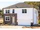 Inviting new construction home with stone and siding exterior, a garage, and manicured landscaping at 556 Barbour Farm Ln, Four Oaks, NC 27524