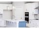 Modern kitchen with white cabinets, stainless steel appliances, a stylish island, and elegant pendant lighting at 556 Barbour Farm Ln, Four Oaks, NC 27524