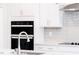 Bright kitchen with white cabinets, stainless steel appliances, a center island, and gray backsplash at 556 Barbour Farm Ln, Four Oaks, NC 27524