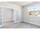 Sunlit office featuring french doors, light gray walls, light wood-look flooring, and a large window at 556 Barbour Farm Ln, Four Oaks, NC 27524