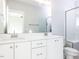 Elegant bathroom featuring dual sinks, white cabinetry, and a modern glass-enclosed shower at 1142 Cottonsprings Dr, Wendell, NC 27591