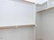 Well-organized walk-in closet with ample shelving and wooden rods for optimal storage solutions at 1142 Cottonsprings Dr, Wendell, NC 27591