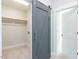 Walk-in closet with tile floor and open barn door for easy access to clothes at 1142 Cottonsprings Dr, Wendell, NC 27591