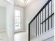 Bright entryway featuring a modern staircase with black railing and light wood flooring at 1142 Cottonsprings Dr, Wendell, NC 27591