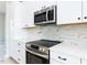 Close-up of the kitchen with stainless steel appliances and white marble-style backsplash at 1142 Cottonsprings Dr, Wendell, NC 27591