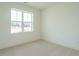 A neutral bedroom with plush carpeting and a large window offering ample natural light at 1146 Cottonsprings Dr, Wendell, NC 27591