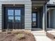 Modern townhome entrance with gray siding and contrasting black trim at 1146 Cottonsprings Dr, Wendell, NC 27591