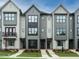 Modern townhome exteriors featuring varying shades of gray, black trim, and well-manicured lawns at 1146 Cottonsprings Dr, Wendell, NC 27591