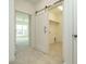 Hallway with a sliding barn door leading to a walk-in closet with wood shelf at 1146 Cottonsprings Dr, Wendell, NC 27591