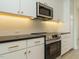 Modern kitchen with white cabinets, black countertops, and stainless steel appliances at 1146 Cottonsprings Dr, Wendell, NC 27591