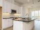 Modern kitchen with white cabinets, black countertops, stainless steel appliances, and large island at 1146 Cottonsprings Dr, Wendell, NC 27591