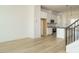 An open kitchen and living space with hardwood floors, white cabinets, and black countertops at 1146 Cottonsprings Dr, Wendell, NC 27591