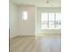 Open-concept living room with hardwood floors, white walls, and large windows at 1146 Cottonsprings Dr, Wendell, NC 27591