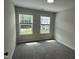 Cozy bedroom featuring carpet flooring and two windows with views of neighborhood at 3010 Freewinds Way # 43, Cary, NC 27519