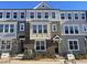 Brick front of charming townhome with gray siding and landscaping at 3010 Freewinds Way # 43, Cary, NC 27519