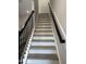 Elegant staircase featuring light-colored steps and a dark handrail at 3010 Freewinds Way # 43, Cary, NC 27519