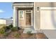 Close-up of a home's front entry showcasing a wooden door, light fixture, and manicured landscaping at 573 Highview Drive Dr, Benson, NC 27504