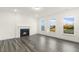 Bright living room with gray wood floors, large windows, and a cozy fireplace, creating a welcoming atmosphere at 573 Highview Drive Dr, Benson, NC 27504
