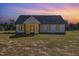 Back exterior view of the house at sunset, showcasing the screened porch at 607 Tuscany Cir, Princeton, NC 27569
