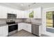 Modern kitchen with white cabinets, granite counters & stainless steel appliances at 607 Tuscany Cir, Princeton, NC 27569