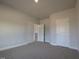 Bedroom featuring neutral carpet, white trim and a door to the hallway at 639 Sweet Potato Lane # 3, Nashville, NC 27856