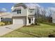 Beautifully landscaped two-story home with a well-maintained lawn, light gray siding, and an attached garage at 82 Gander Dr, Benson, NC 27504