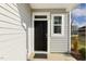 Welcoming entryway featuring a classic black door, white trim, and light gray siding at 82 Gander Dr, Benson, NC 27504