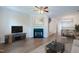 Bright living room features a cozy fireplace, ceiling fan, and an open floor plan at 128 Dove Cottage Ln, Cary, NC 27519