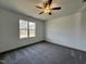 Bedroom featuring neutral carpeting, a large window with bright natural light, and a ceiling fan at 234 Danube Dr, Zebulon, NC 27597