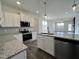 Well-equipped kitchen with granite counters, stainless steel appliances, and view into adjacent living room at 234 Danube Dr, Zebulon, NC 27597