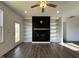 Open living room with fireplace, built-in bookshelves, ceiling fan, and access to outdoor space at 234 Danube Dr, Zebulon, NC 27597