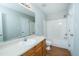 Bathroom with a modern sink, wood cabinets, mirror, and tub with shower at 310 E Horton St, Zebulon, NC 27597