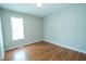 Cozy bedroom featuring wood-look floors, natural light, and neutral color scheme at 310 E Horton St, Zebulon, NC 27597