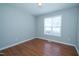 A clean bedroom with new flooring, light paint, and natural light from the window at 310 E Horton St, Zebulon, NC 27597