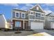 Two-story house with gray siding, white garage door, and landscaping at 26 Steppe Way, Garner, NC 27529
